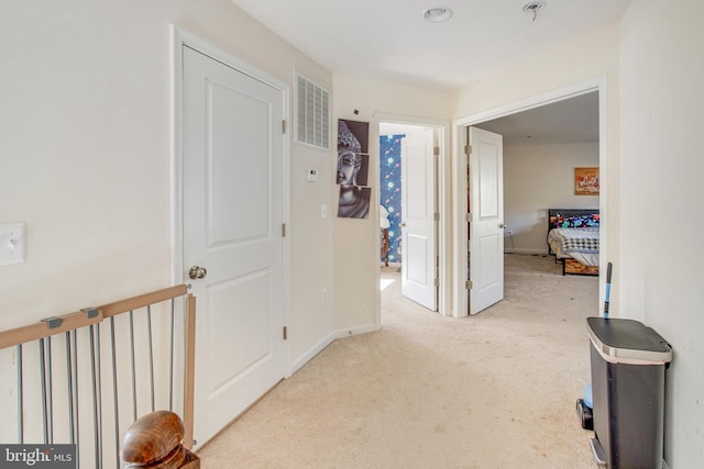 hallway with light colored carpet