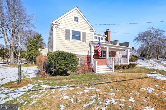 view of front of home featuring covered porch and a lawn