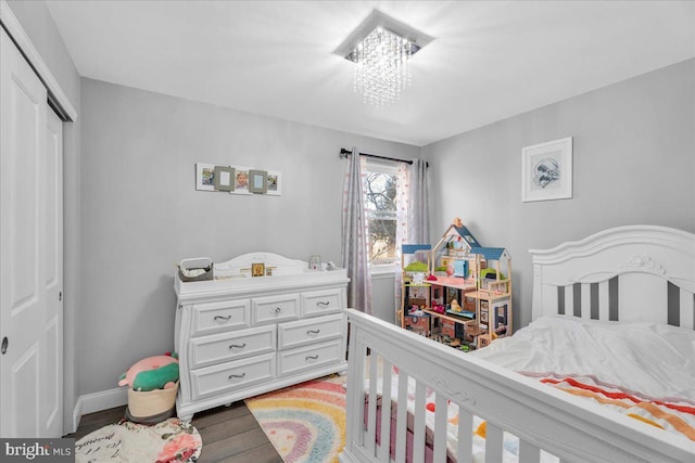 bedroom with a notable chandelier, a closet, and hardwood / wood-style floors