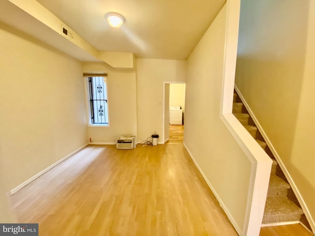 spare room featuring washer / clothes dryer and hardwood / wood-style floors