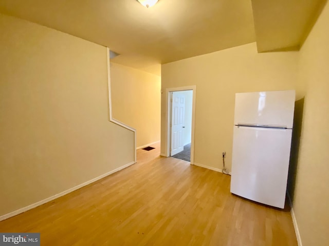 interior space featuring hardwood / wood-style flooring and white refrigerator