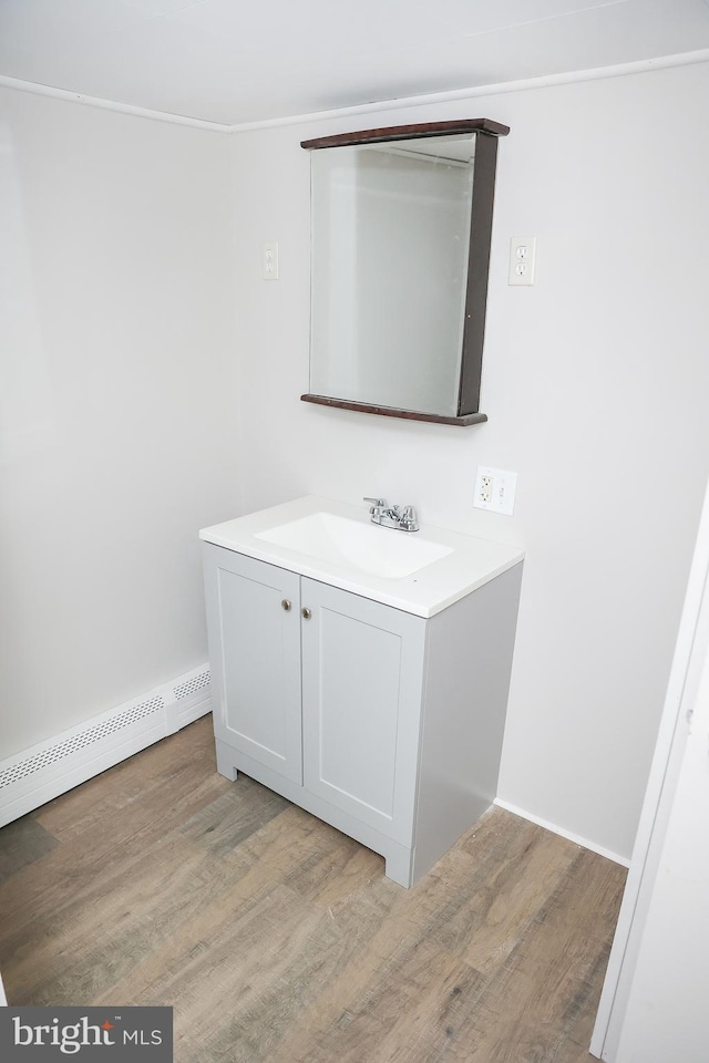 bathroom with hardwood / wood-style flooring, vanity, and baseboard heating