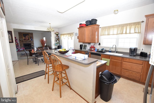 kitchen featuring a fireplace, a kitchen bar, plenty of natural light, and sink