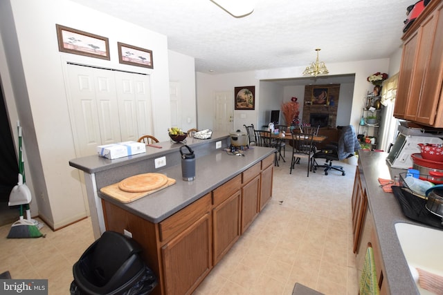 kitchen featuring a textured ceiling, a kitchen island, and sink