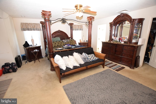 bedroom with ceiling fan, multiple windows, and light carpet