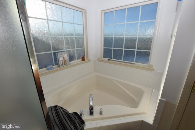 bathroom with a relaxing tiled tub