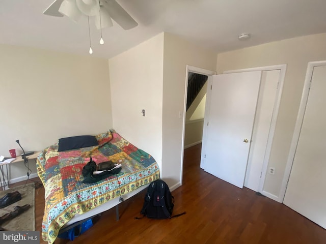 bedroom featuring ceiling fan, a closet, and dark hardwood / wood-style flooring