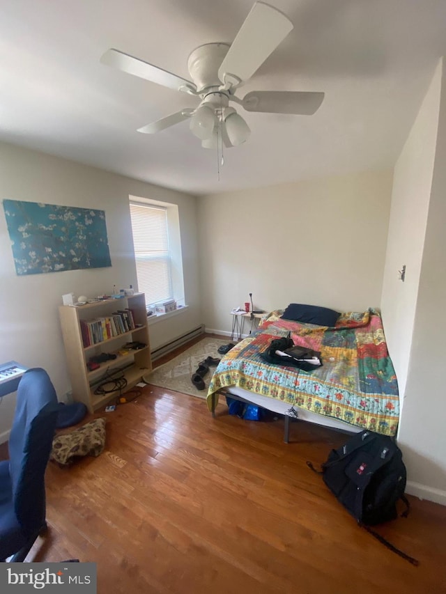 bedroom with ceiling fan, baseboard heating, and hardwood / wood-style flooring