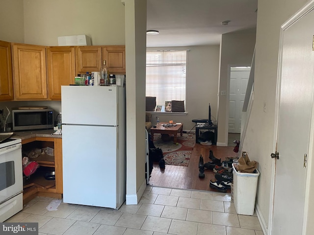 kitchen featuring white appliances and light tile patterned flooring