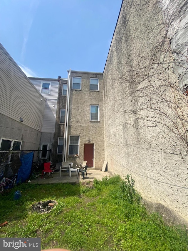 rear view of house featuring a yard and a patio