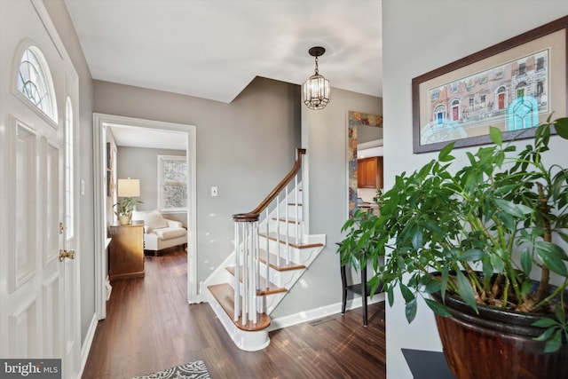 entrance foyer with dark hardwood / wood-style flooring and a chandelier