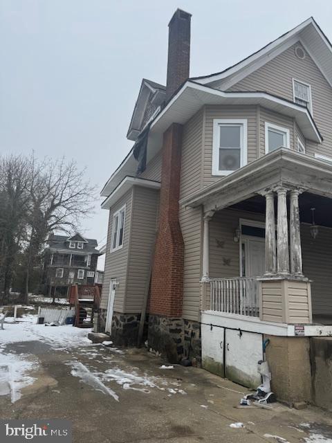 view of snow covered exterior featuring covered porch