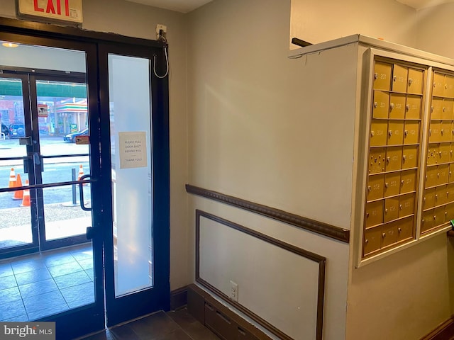 entryway featuring mail boxes and dark tile patterned floors