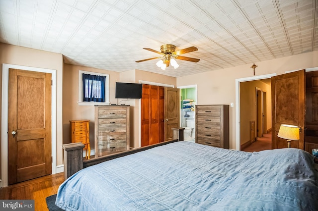 bedroom featuring hardwood / wood-style flooring, ceiling fan, and a closet