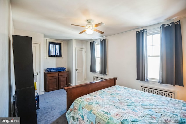 bedroom with carpet floors, ceiling fan, radiator, and multiple windows