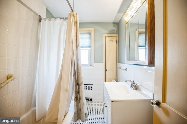 bathroom featuring radiator, vanity, tile walls, and shower / bath combo with shower curtain