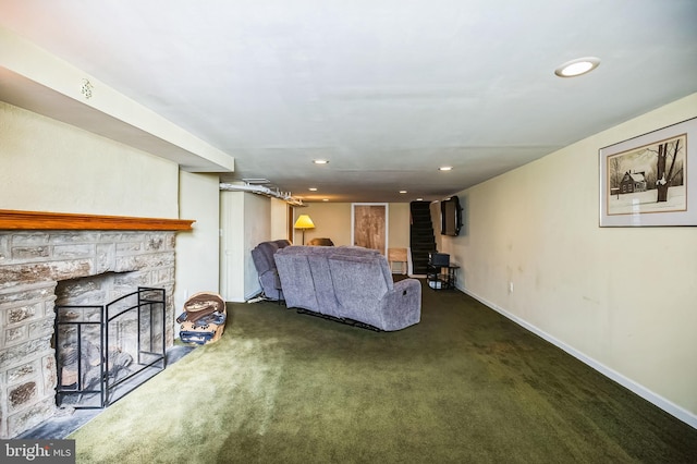 living room with a stone fireplace and dark carpet