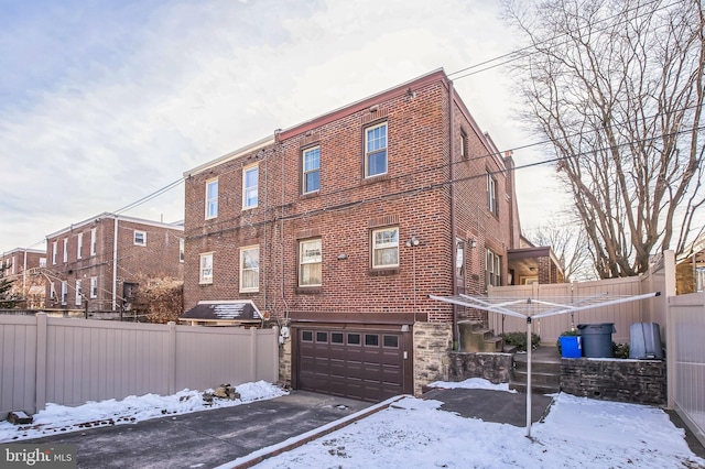 view of snow covered exterior with a garage