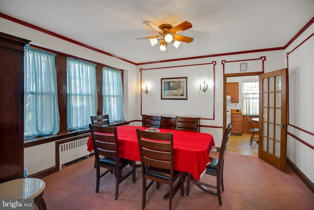 dining area featuring french doors, ceiling fan, carpet, ornamental molding, and radiator heating unit