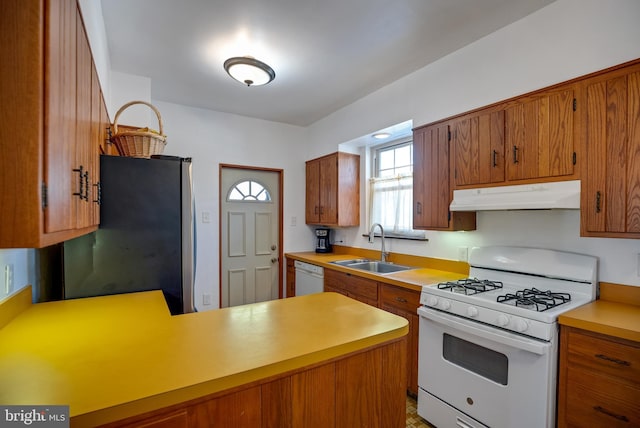 kitchen featuring sink, white appliances, and kitchen peninsula