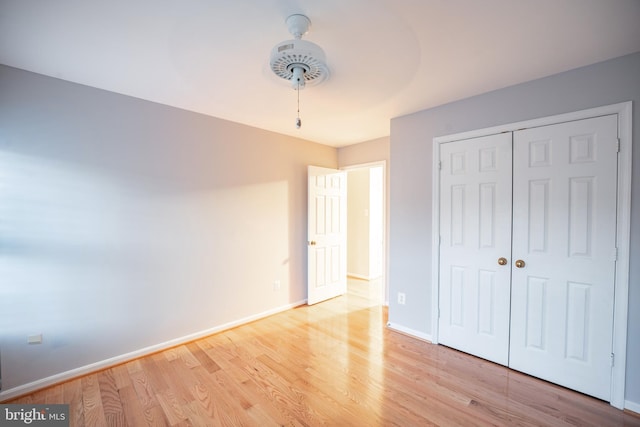 unfurnished bedroom featuring a closet, ceiling fan, and light wood-type flooring