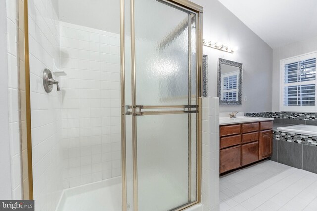 bathroom featuring lofted ceiling, shower with separate bathtub, and vanity