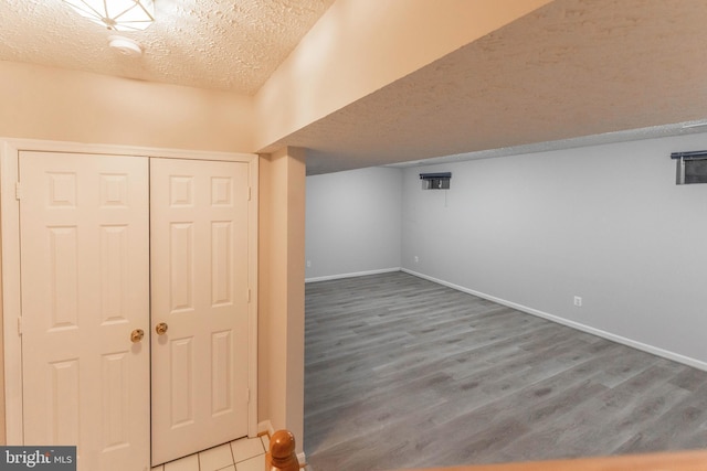 basement with hardwood / wood-style flooring and a textured ceiling