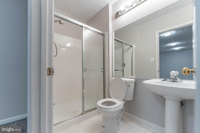 bathroom featuring walk in shower, toilet, sink, and a textured ceiling