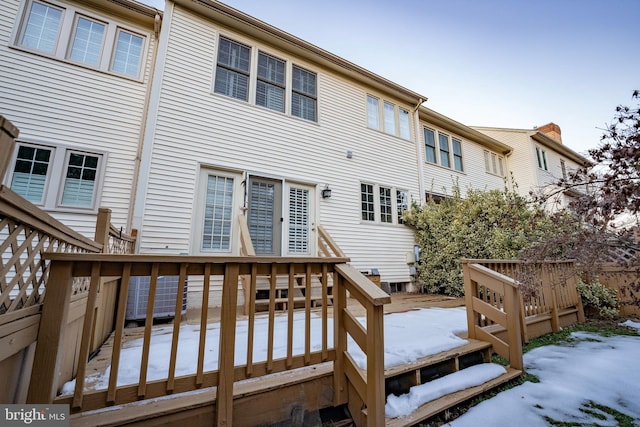 snow covered house featuring a deck