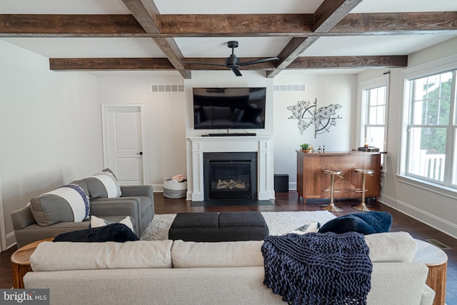 living room with ceiling fan, a fireplace with flush hearth, visible vents, and baseboards