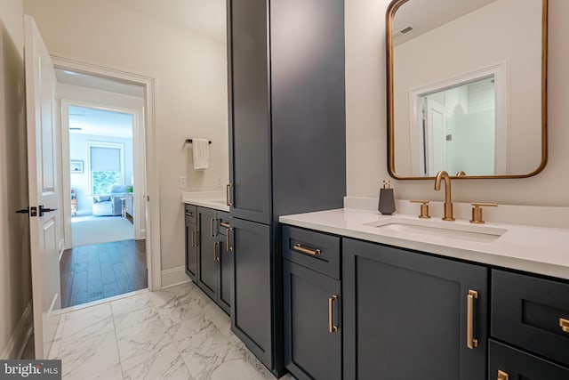 bathroom featuring marble finish floor, baseboards, and vanity