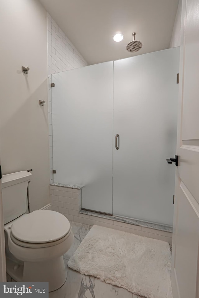 bathroom with a stall shower, marble finish floor, and toilet