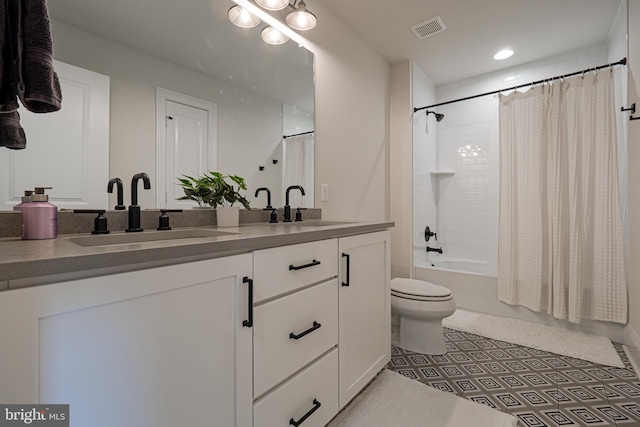 full bathroom featuring toilet, double vanity, a sink, and visible vents