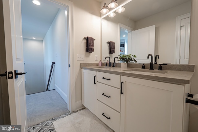 bathroom featuring a sink, baseboards, and double vanity