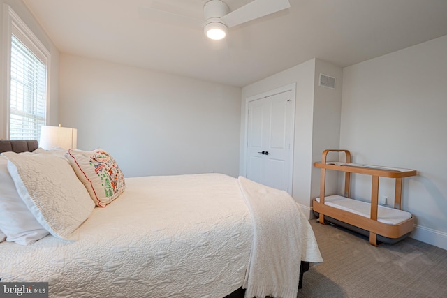 carpeted bedroom with a closet, visible vents, ceiling fan, and baseboards