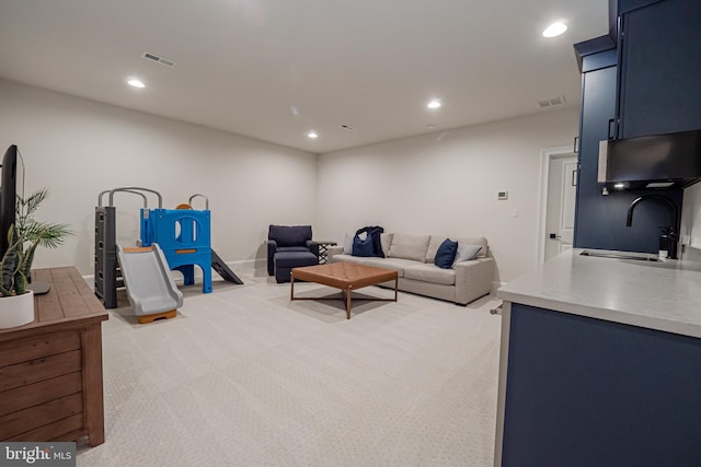 living area featuring light carpet, visible vents, and recessed lighting