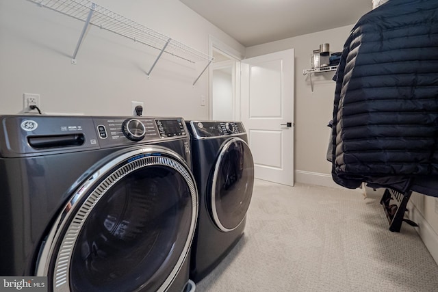 laundry room with baseboards, laundry area, washing machine and dryer, and light colored carpet