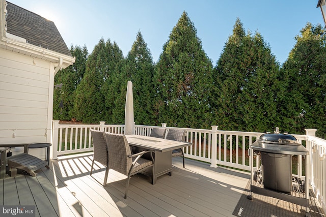 deck with outdoor dining space and grilling area