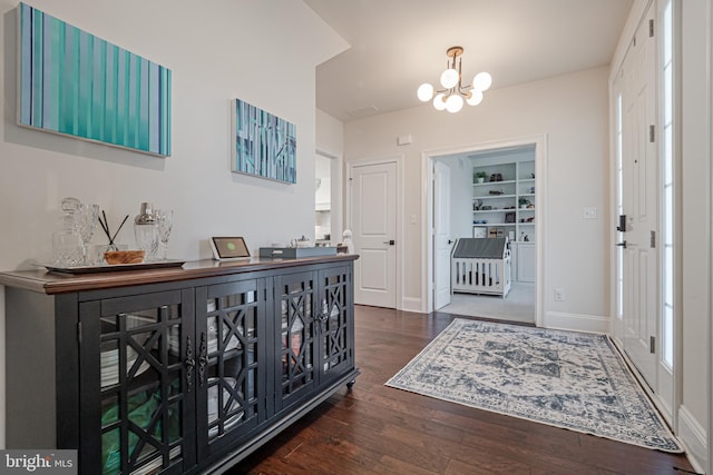 entrance foyer with an inviting chandelier, baseboards, and wood finished floors