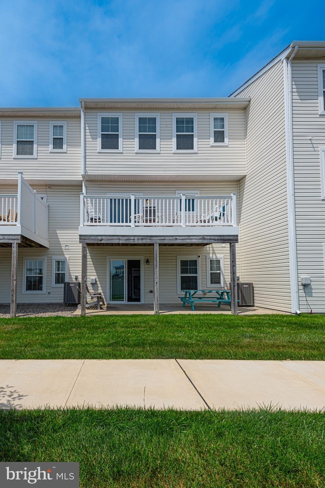 view of property with central air condition unit, a patio area, and a front lawn