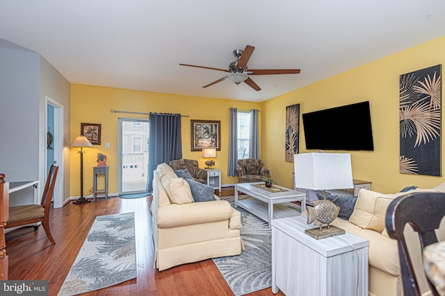 living room featuring wood-type flooring and ceiling fan