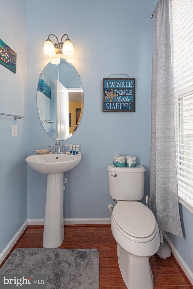 bathroom with toilet and wood-type flooring