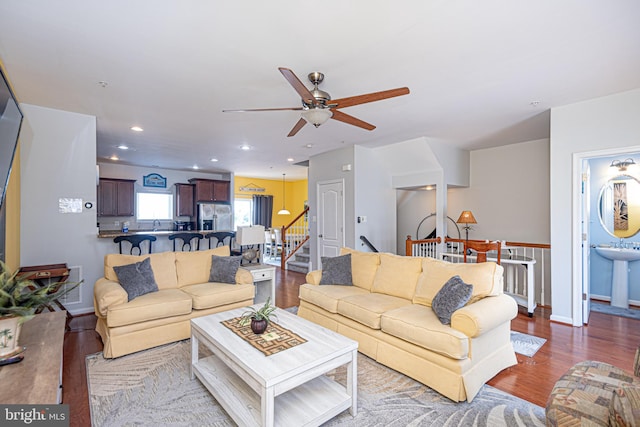 living room with ceiling fan, sink, and wood-type flooring