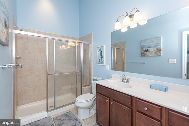 bathroom with toilet, vanity, tile patterned floors, and walk in shower