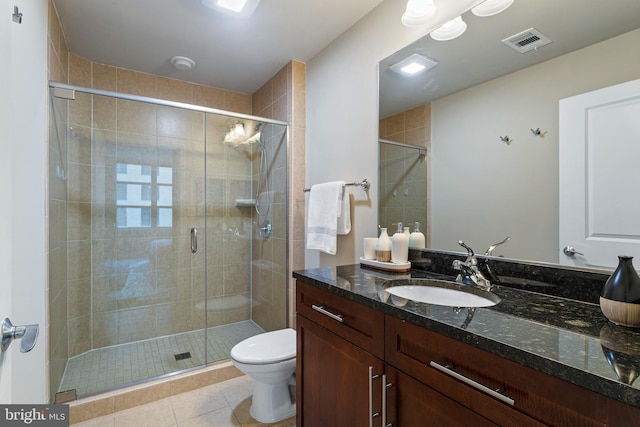 bathroom featuring walk in shower, vanity, toilet, and tile patterned flooring