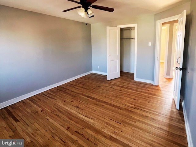 unfurnished bedroom with hardwood / wood-style flooring, ceiling fan, and a closet