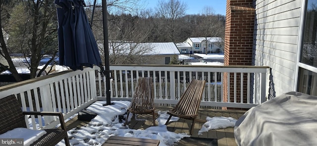 snow covered deck with a grill