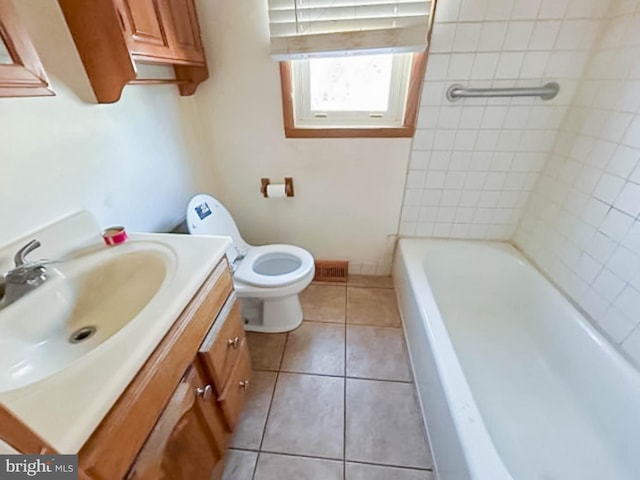 bathroom with toilet, a bathtub, tile patterned floors, and vanity