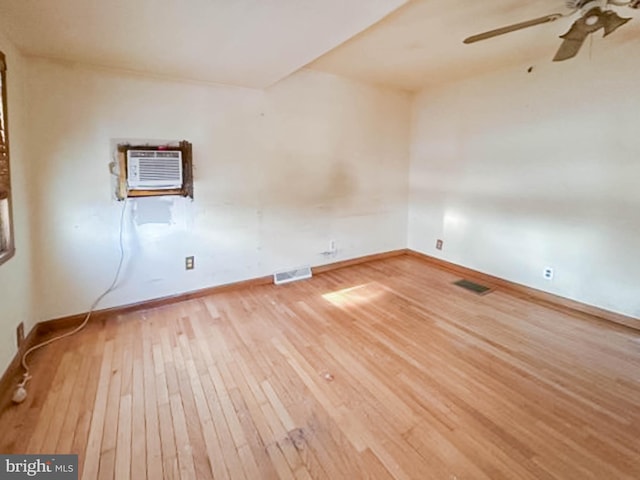 spare room featuring hardwood / wood-style flooring, ceiling fan, and a wall mounted air conditioner