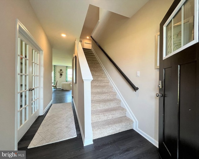 stairs with hardwood / wood-style flooring and french doors